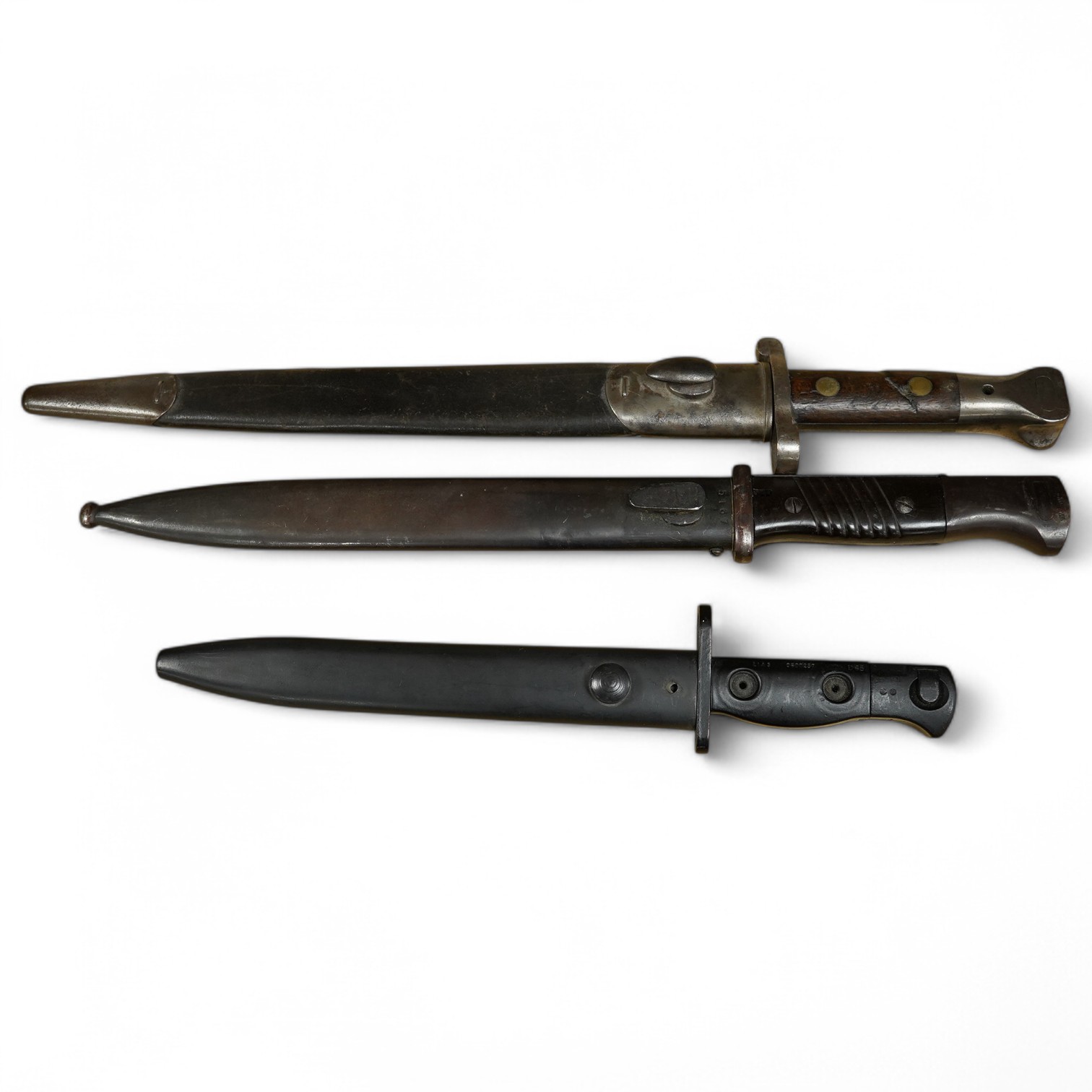 Three various bayonets and scabbards including one Sandersons of Sheffield, longest 44cm. Condition - fair